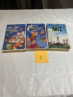 Front covers of the three VHS movies Space Jam, Hercules, and Antz with visible artwork and titles, placed side by side on a white cloth.