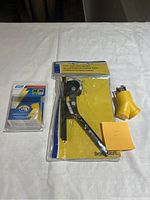 Full lot view showing the tube bender in original packaging and two yellow generator adapters on white surface.