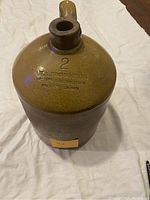 Front view of the 2 gallon jug showing embossing and spout detail.