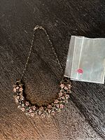 Photo of complete necklace showing floral design with pink Austrian crystal stones and chain with lobster clasp.