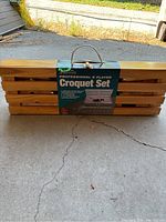 Wooden croquet set case labeled as professional 6 player set, showing carry handle and packaging label.
