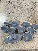 Full set including ten blue cups with matching saucers, small tray, and salt and pepper shakers.