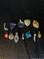 Photo showing all twelve assorted pendants on a dark surface for visual reference of the collection.