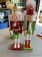 Pair of hand-painted wooden nutcrackers standing on a table indoors with visible background items.