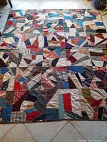 Full view of the antique handmade crazy quilt showing multicolored patchwork design and overall condition.