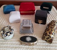 All 9 jewellery boxes arranged on a beige quilted surface showing size, shape, and external details including the sterling silver engagement ring box monogrammed with letter B, velvet boxes, faux leather boxes, metal storage boxes, and a leopard print lipstick holder.