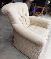 Side front angle view showing fabric pattern, tufted backrest, and armrest shape.