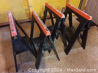 Four assembled sawhorses standing open on floor