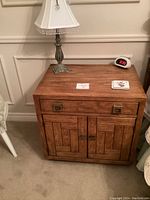Front view of nightstand with lamp and clock showing overall condition