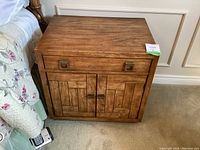 Front three-quarter view of nightstand showing drawer and cabinet doors