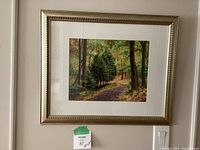 Framed nature print hung on a wall, centered in a gold decorative frame with a white mat