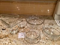 All items arranged on kitchen counter showing full set of mixing bowls, loaf pan, square pan, and prep bowls.