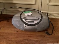 Front angled view of Sony boom box showing speaker grills, power cord, and top control panel with CD player lid and buttons