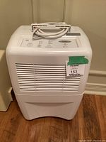 Front view of white Whirlpool Gold dehumidifier showing vents and power cord on top with label.