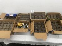 Six cardboard boxes filled with clear glass canning jars and one box with assorted metal canning jar lids and screw bands.