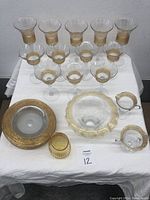 Full set of 13 items including stemmed glasses, pitcher, serving bowls, and plate arranged on a white cloth.