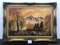 Frontal view of the framed vintage oil painting depicting an autumn landscape with mountains and a pond.