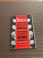Front cover of The Beatles 20 Wallet Photos booklet showing black and white images of the band and red band listing contents including horoscopes and biographies.