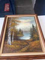 Full view of the framed forest scene oil painting showing autumn birch trees, pine trees, and lake with natural wood frame.