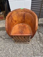 Top-down view of leather chair showing worn leather seat and backrest with rounded shape.