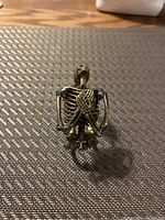 Close-up photo of the skeleton bracelet showing the front with the skeleton ribcage and crossed arms detail.