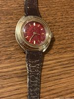 Front view of women's Timex mechanical wristwatch showing gold-tone oval case and brown patterned leather strap