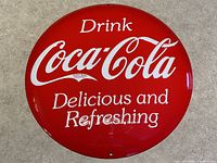 Front view of the 14-inch round red Coca-Cola metal button sign showing full text and domed shape.