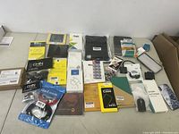 Full lot showcasing all cell phone and electronic accessories on a table, varies in packaging condition and size.