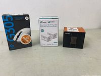 Lot shows three boxed items: Logitech G305 mouse, TP-Link Kasa Smart Wi-Fi Plug Mini, and Netgear Wi-Fi Extender.