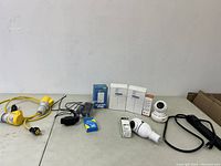 Overview of all items on table showing cables, cameras, and boxed electronics