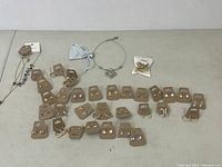 Overview of costume jewelry items including earrings on brown display cards and necklaces laid out on a surface.