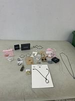 Overview of lot with assorted costume jewelry displayed on table including necklaces, bracelets, earrings, and boxed items.
