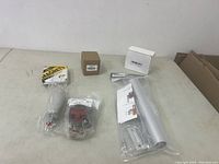 Photo of miscellaneous new items on table including components in packaging, a magnet, and antenna mount.