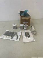 Photo showing the entirety of the lot containing wire spools, sealed tool sets, a water pump part, and the multi-tool packaging