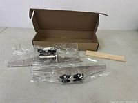 Full view of stair tread template jig set including templates, clamps, wood step riser piece, and cardboard box