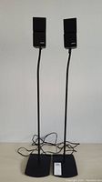 Pair of BOSE speakers mounted on tall stands with flat bases, both standing 41 inches tall.