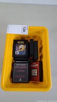 Yellow bin with nine vintage Atari 2600 cartridges including Pac-Man and Space Invaders visible