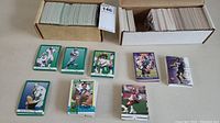 Two boxes packed with football cards mostly 1991 Fleer cards shown face up with players in various poses