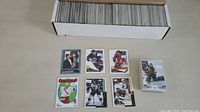 Box containing over 600 sleeved hockey cards with sample cards laid out in front including players Mark Messier, Paul Coffey, Mike Modano, and Ray Bourque.