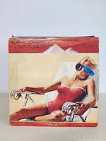Rolling Stones “Made in the Shade” album cover featuring reclining figure in red swimsuit and blue sunglasses