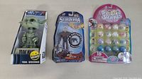 Lot of 3 toys in original packaging: Star Wars Yoda Wisecrack, Slugterra Dr. Blakk, and Squinkies 16-pack. Packaging shows wear.