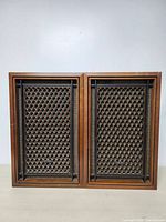 Front view of two AKAI SW-155 vintage speakers with diamond patterned mesh grills and AKAI badges.