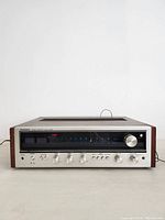 Front view of vintage Pioneer SX-535 stereo receiver showing tuner display, control knobs, and switches on silver aluminum faceplate with wood veneer sides.