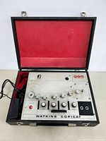 Open clamshell case showing tape echo unit with control panel and cables