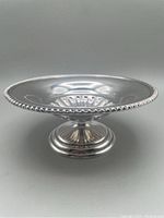 Side perspective showing round bowl atop fluted pedestal foot