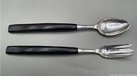 Full view of the two salad server pieces: a spoon and a fork with dark wooden handles and silver heads.