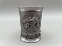 Front view of pewter shot glass with embossed Harley Owners Group 10th Anniversary logo and dates 1983-1993