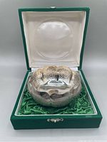 Bowl seated in open green velvet and satin lined hinged box