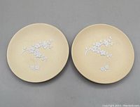 Two primrose yellow round Wedgwood Jasperware trinket dishes each with white relief plum blossom decoration.