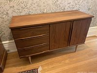 Front view of walnut sideboard showing three drawers and double doors